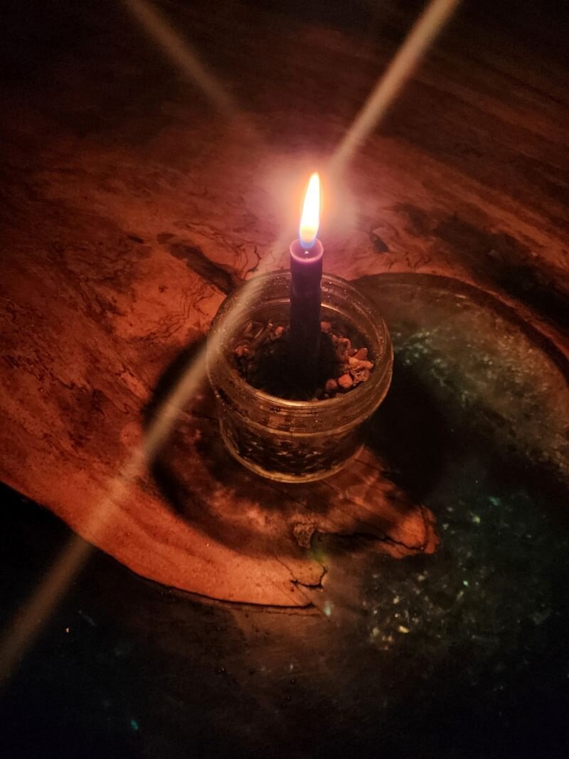 A candle burning in a dish