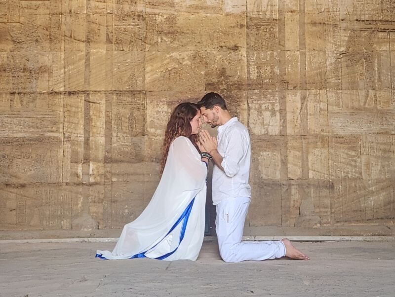 Couple kneeling forehead to forehead at a temple